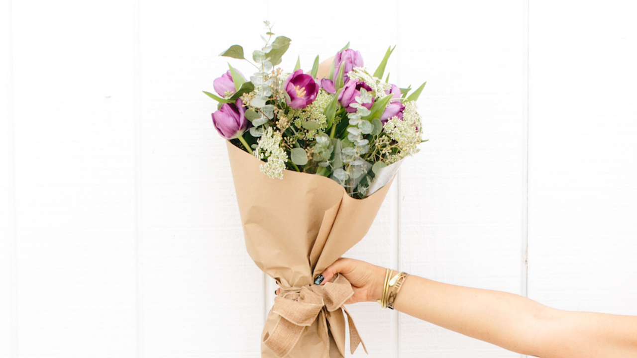 Image of hand holding flowers (Subscription Box Ideas for Product Businesses by Moira Fuller Business Coach)