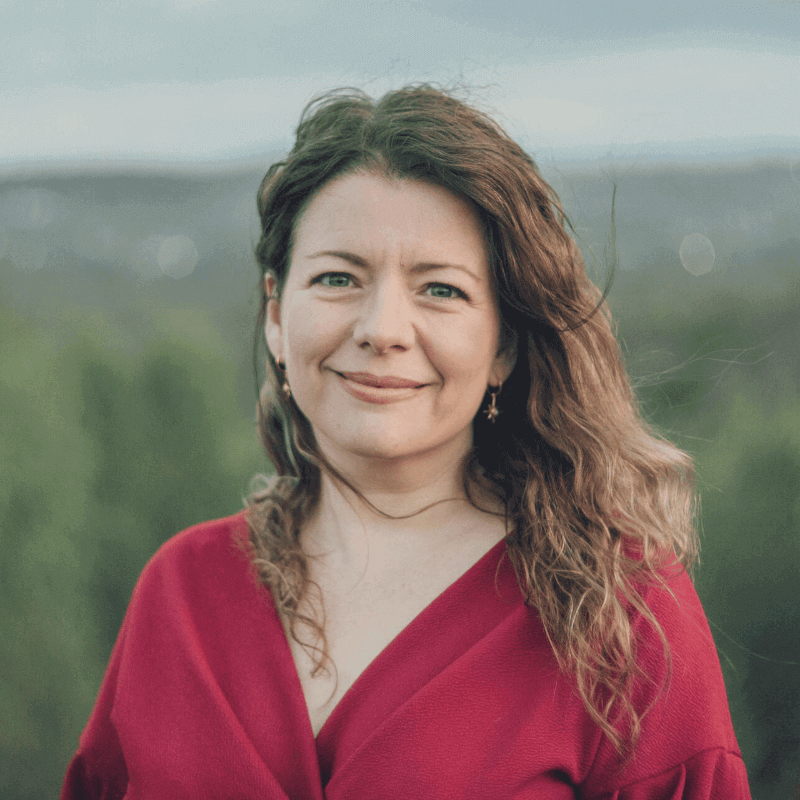 Moira Fuller, Business Mentor, smiling in red top outdoors