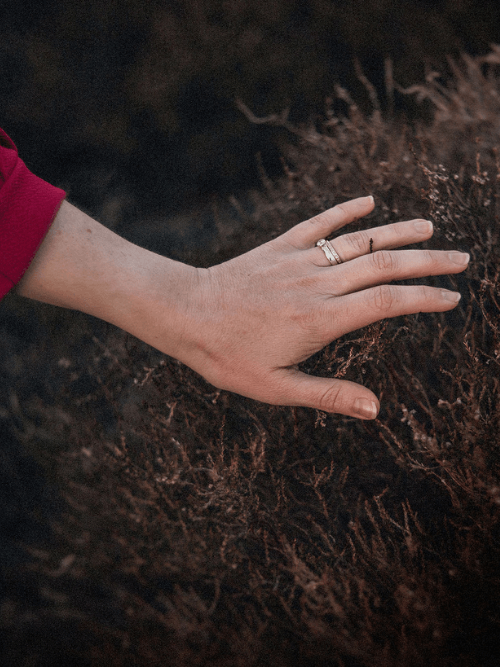 woman writing in a notebook wearing a soft pink jumper