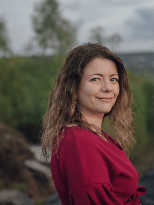 woman writing in a notebook wearing a soft pink jumper